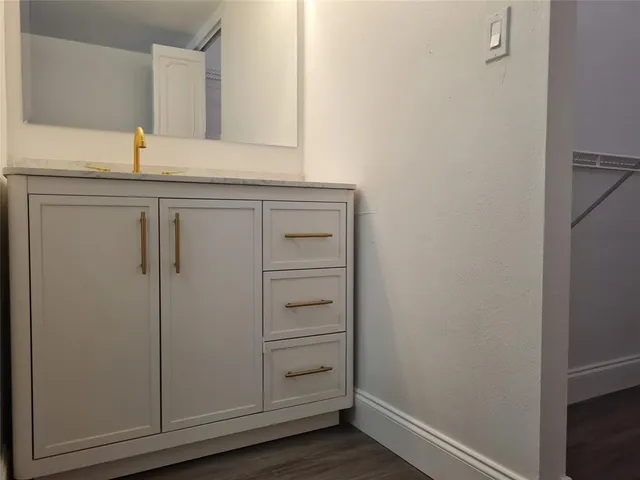 a bathroom with a granite countertop sink and mirror
