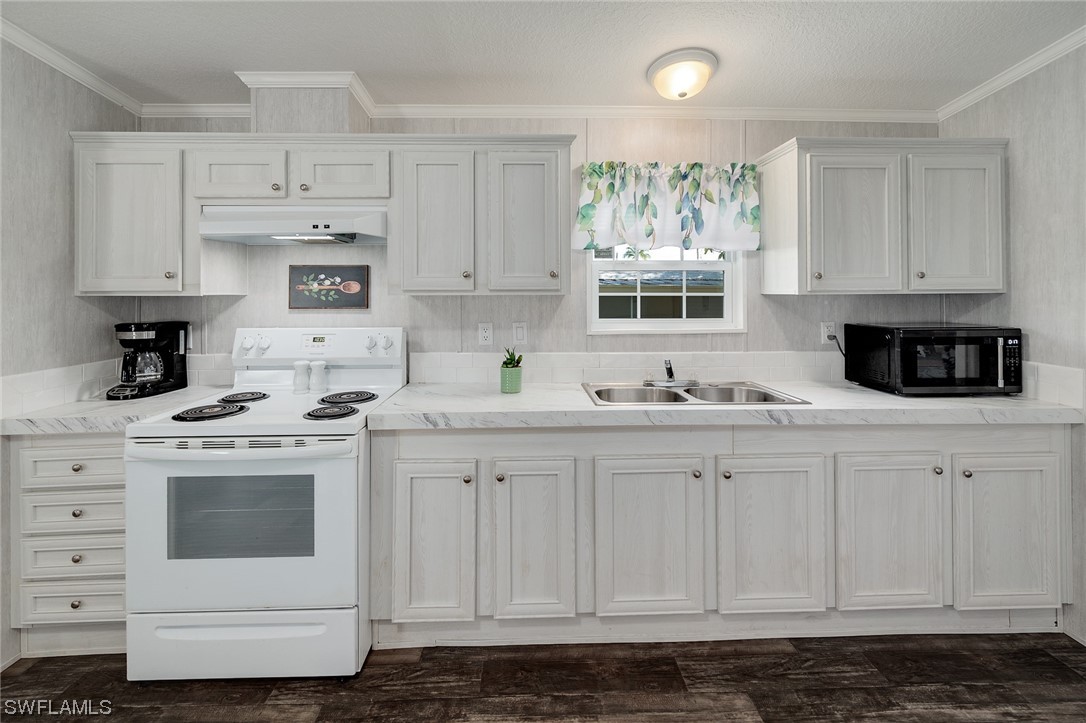 132 Cape Sable Drive Naples, FL 34104 - Photo 11 of 20 a kitchen with granite countertop white cabinets and white appliances
