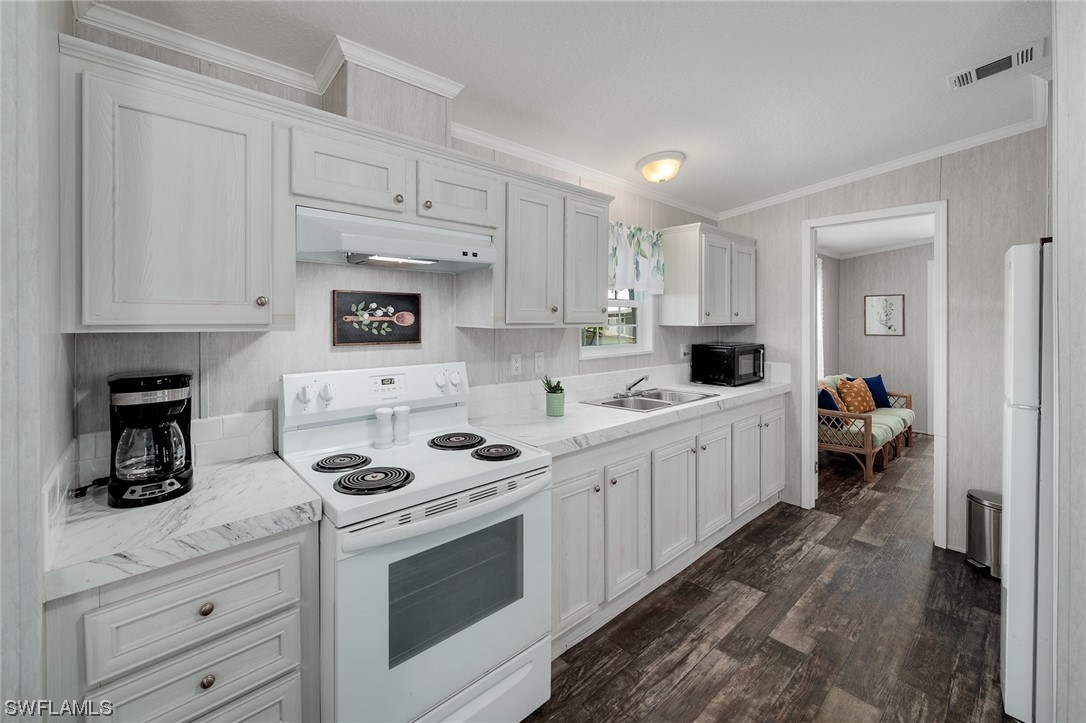 132 Cape Sable Drive Naples, FL 34104 - Photo 10 of 20 a kitchen with white cabinets sink and white appliances