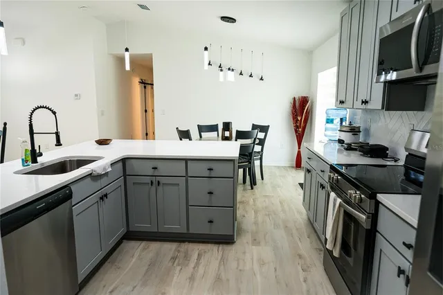 a kitchen with a sink appliances and cabinets