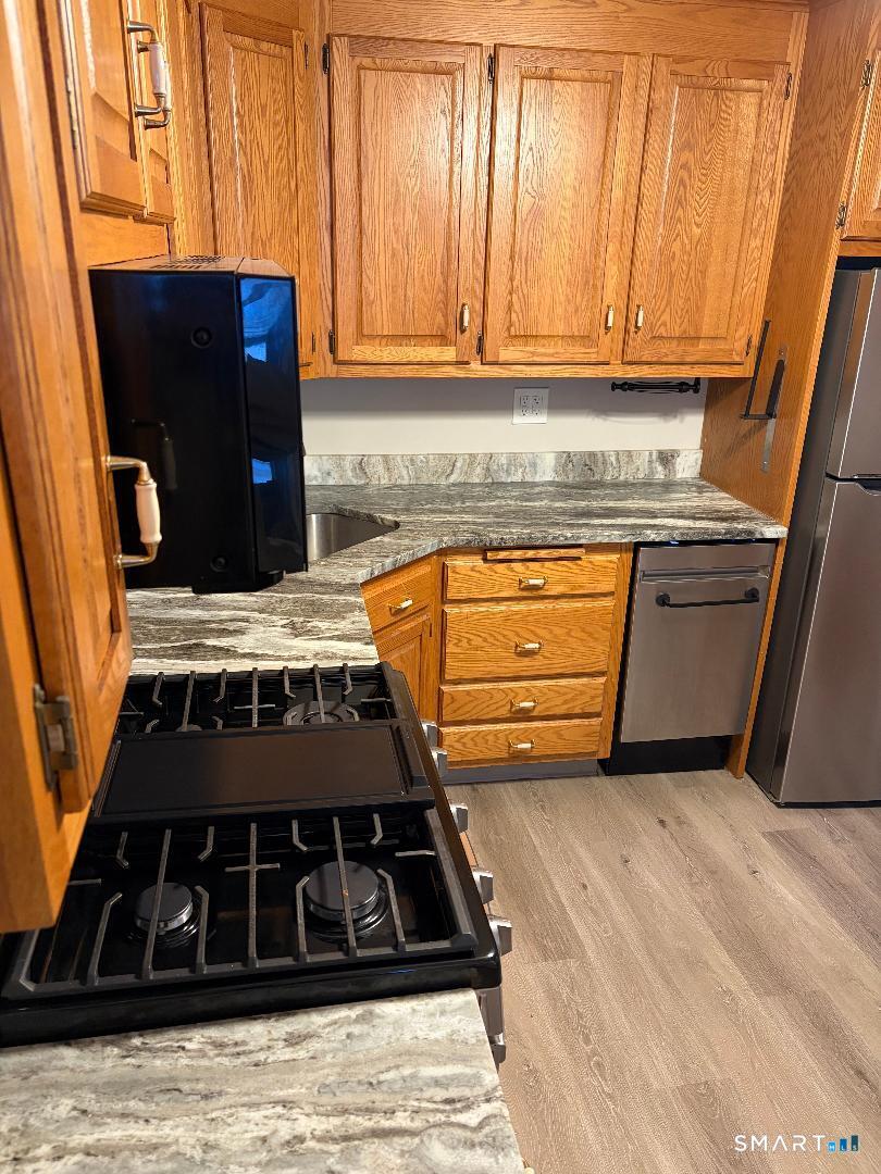65 Ingraham Street, Unit 2 Bristol, CT 06010 - Photo 2 of 11 a kitchen with stainless steel appliances granite countertop a stove and a refrigerator