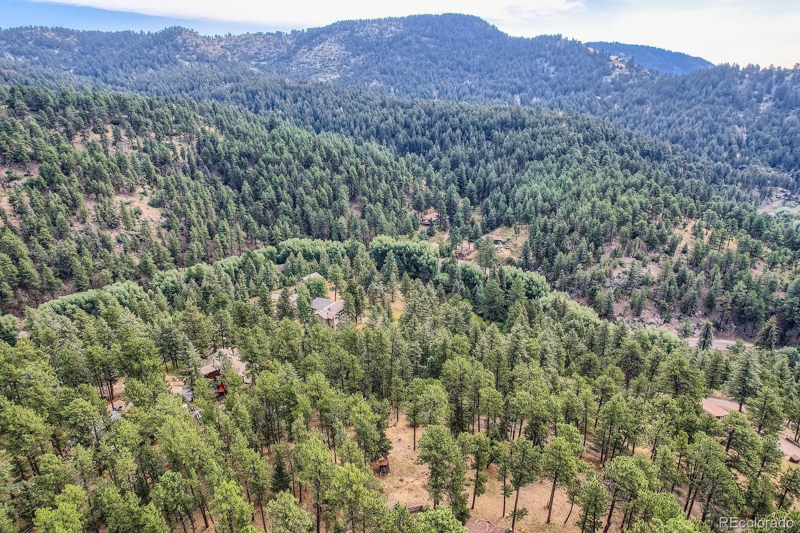 5296 Cherokee Road Indian Hills, CO 80454 - Photo 14 of 26 a view of a lush green hillside and a houses