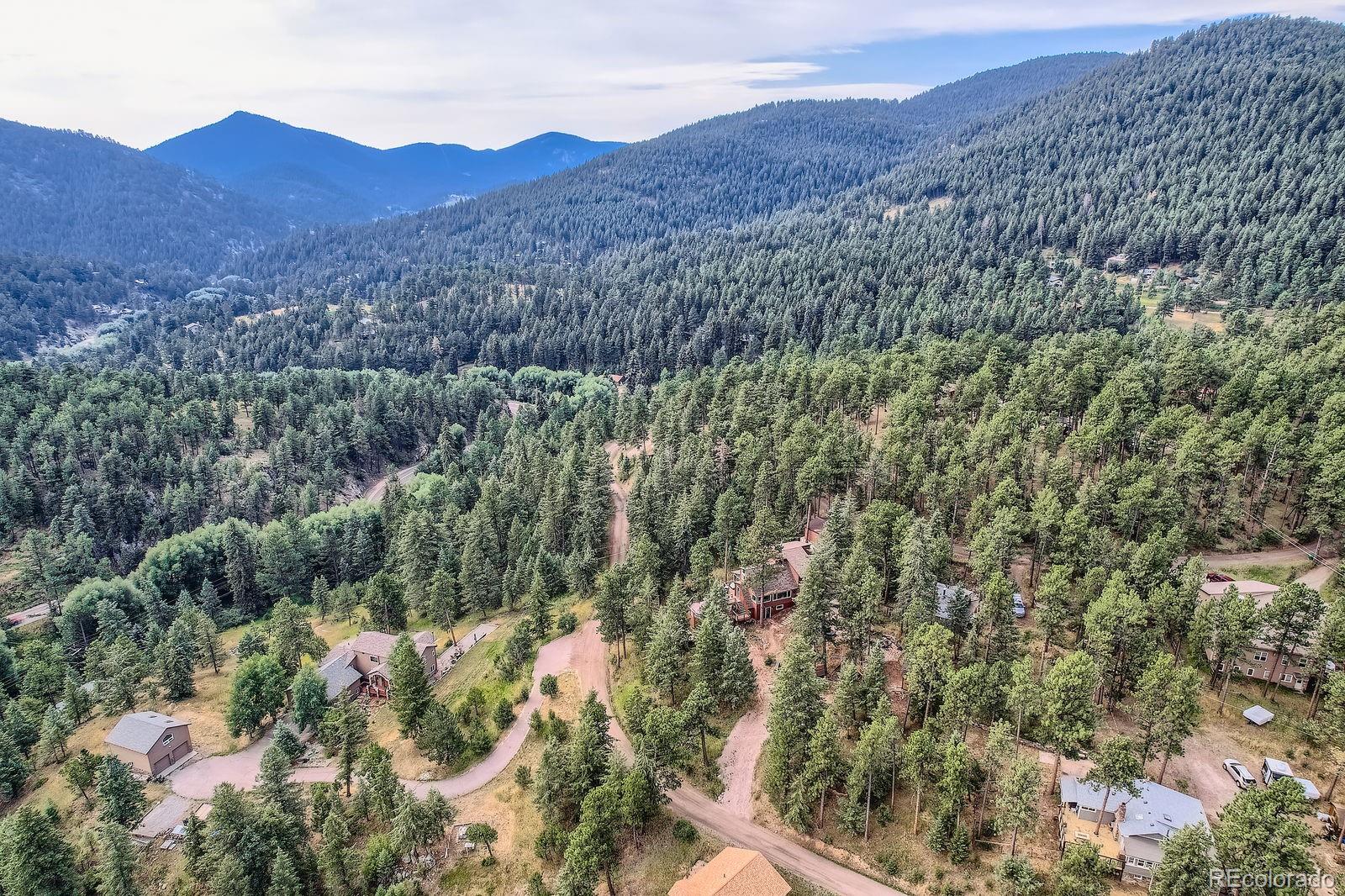5296 Cherokee Road Indian Hills, CO 80454 - Photo 19 of 26 a view of a mountain in the distance in a field