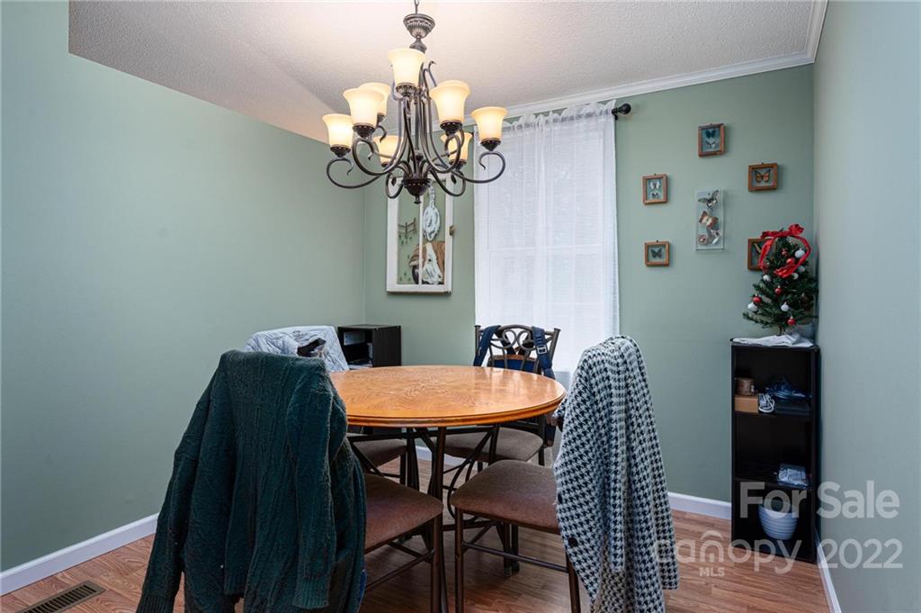2776 Devine Road Iron Station, NC 28080 - Photo 4 of 23 a dining room with furniture wooden floor and a chandelier
