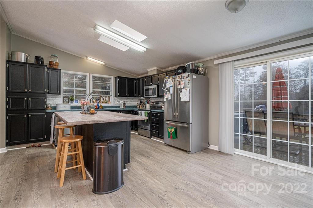 2776 Devine Road Iron Station, NC 28080 - Photo 8 of 23 a kitchen with kitchen island a counter top space a sink stainless steel appliances and cabinets