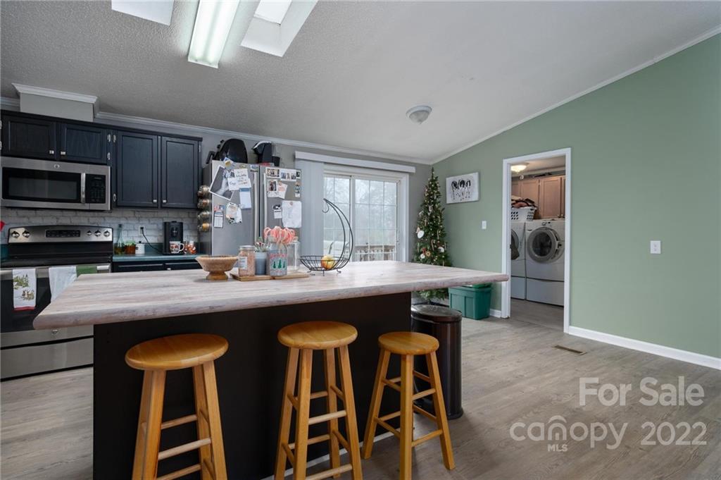 2776 Devine Road Iron Station, NC 28080 - Photo 9 of 23 a kitchen with stainless steel appliances granite countertop a sink and a refrigerator