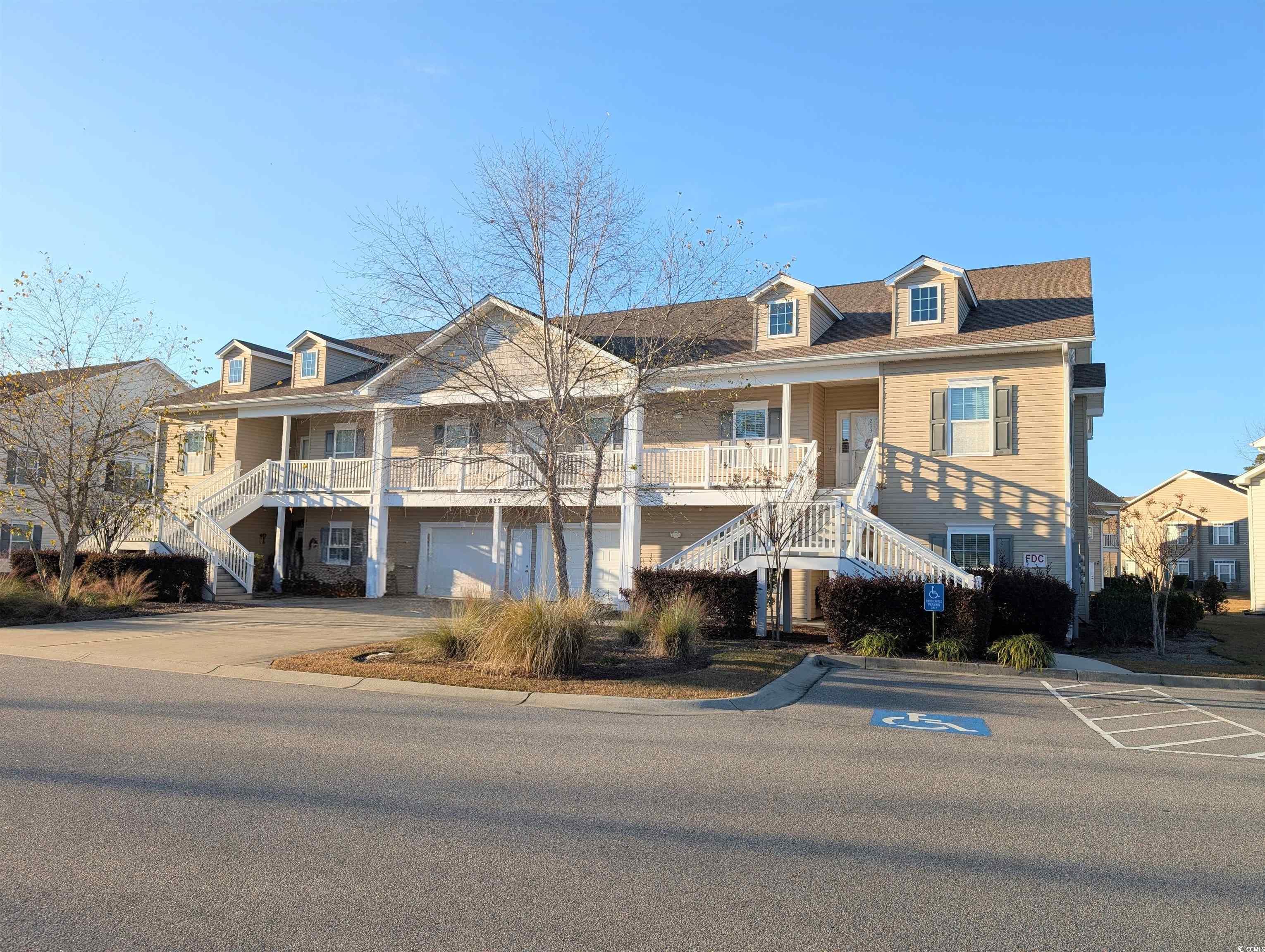 View of front of home featuring stairs, covered porch, and driveway
