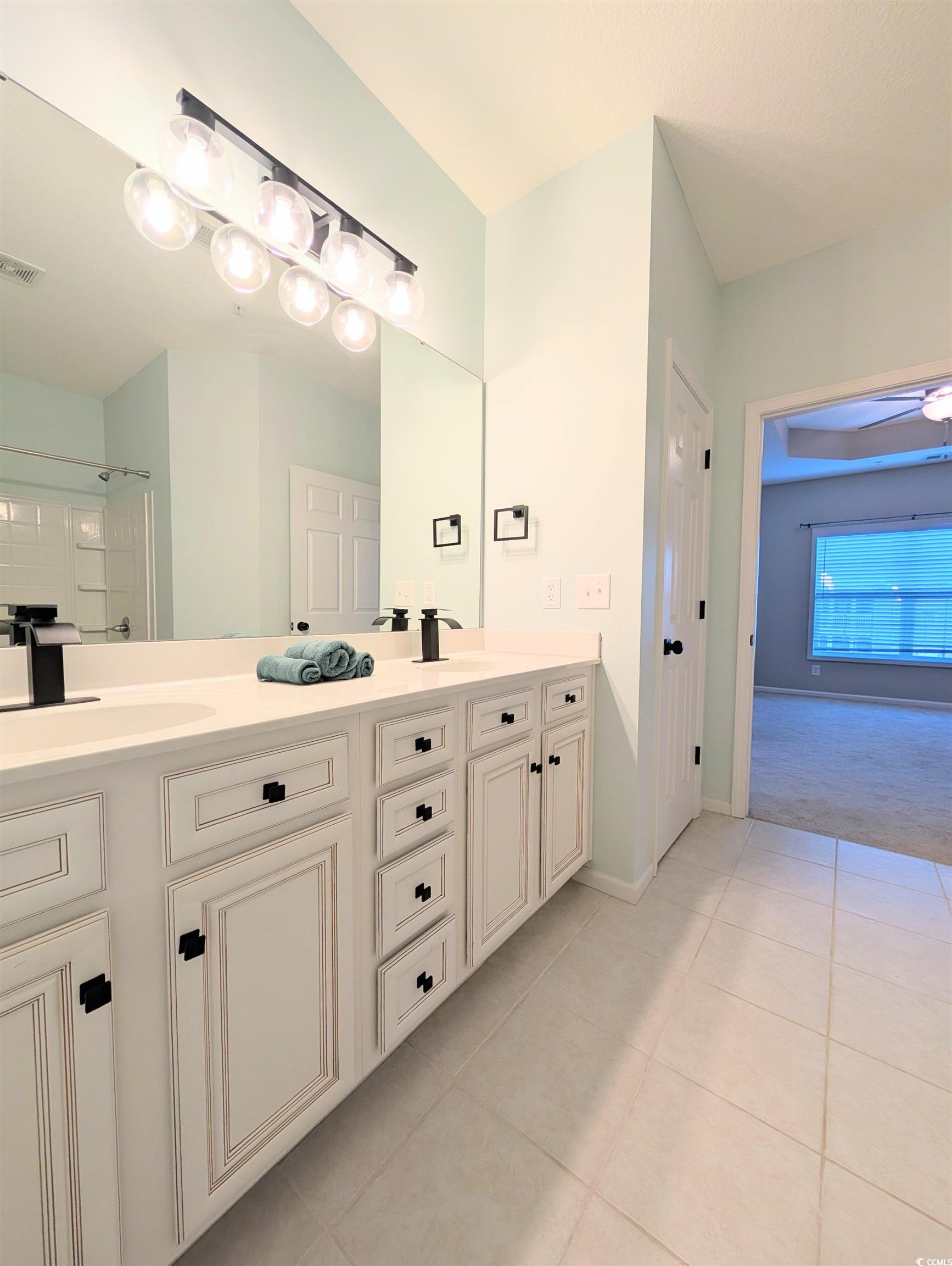 822 Sail Lane Murrells Inlet, SC 29576 - Photo 19 of 34 Bathroom with double vanity, light tile patterned floors, and a shower