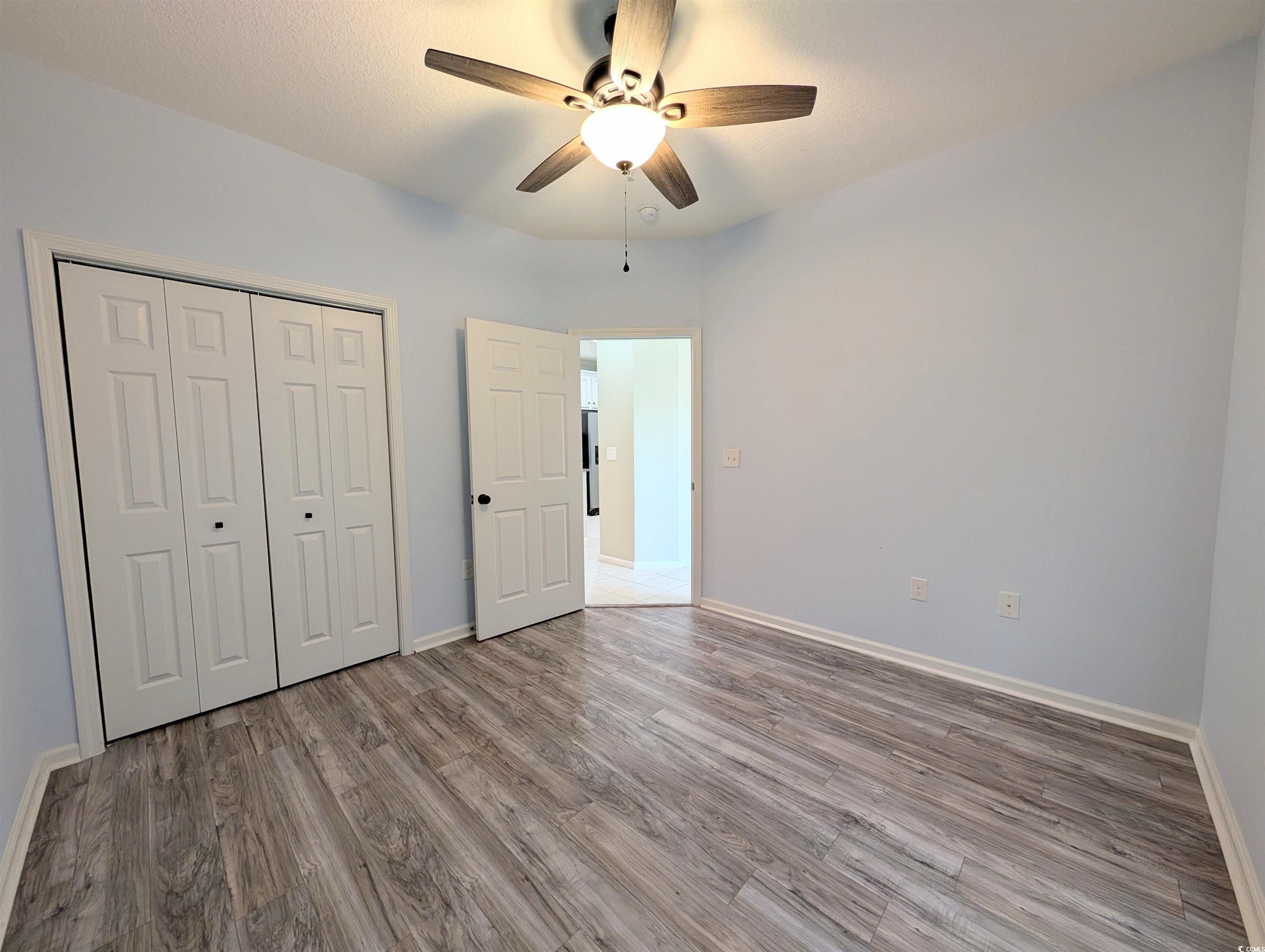 822 Sail Lane Murrells Inlet, SC 29576 - Photo 26 of 34 Unfurnished bedroom featuring wood finished floors, ceiling fan, and a closet