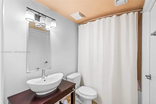 a bathroom with a sink mirror and toilet