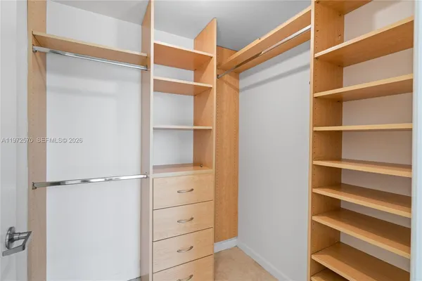 a view of walk in closet with empty racks