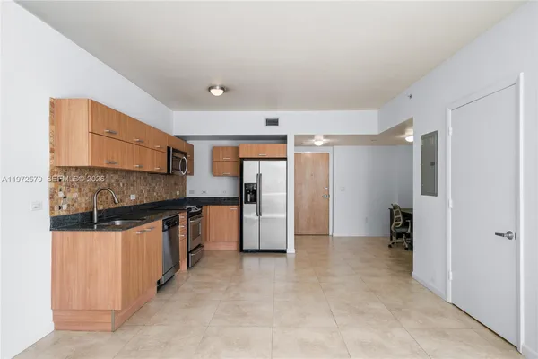 a kitchen with stainless steel appliances granite countertop a refrigerator and a stove