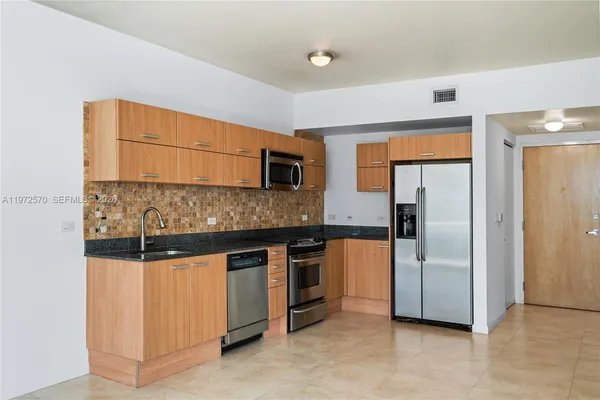 a kitchen with stainless steel appliances granite countertop a refrigerator and a stove
