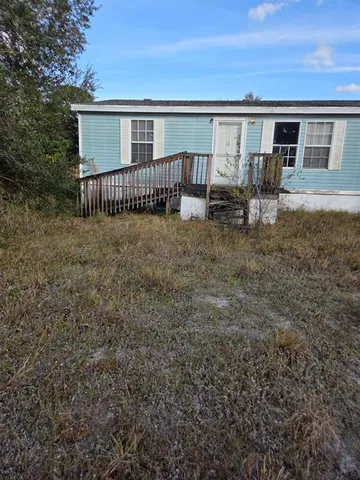 a view of a house with a yard and sitting area