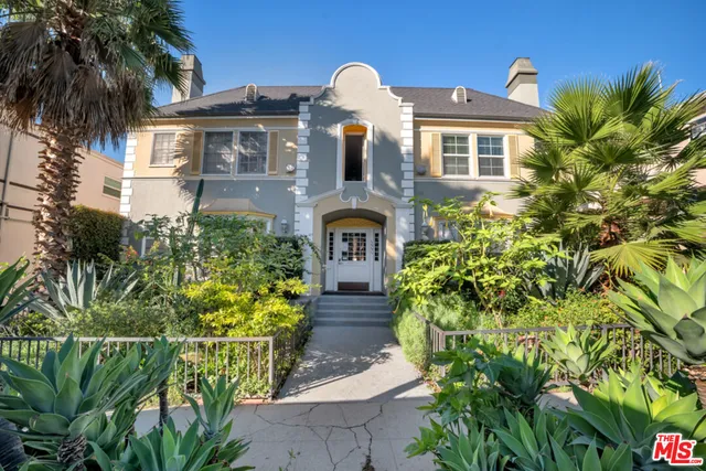 a front view of a house with a garden