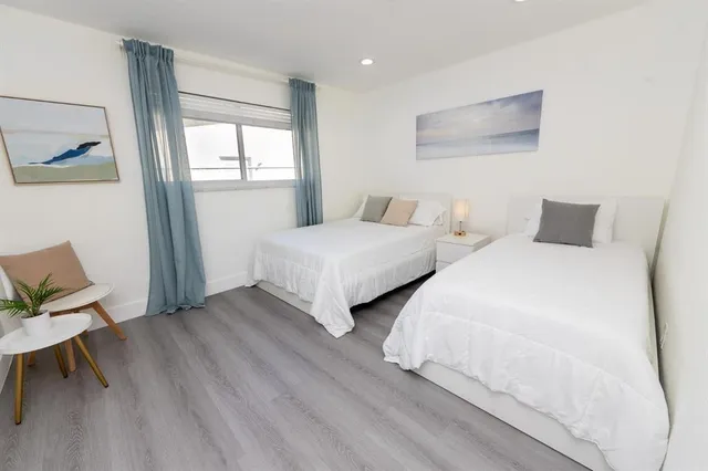 a bedroom with two beds and painting on the wall