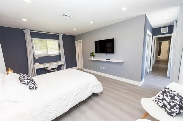 a bedroom with a bed and a flat screen tv