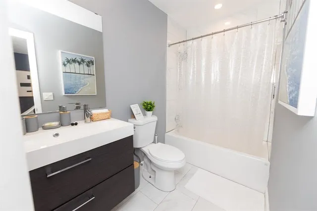 a bathroom with a sink a toilet and shower curtain