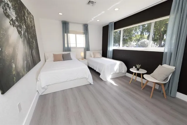 a large white bed sitting in a room next to a window