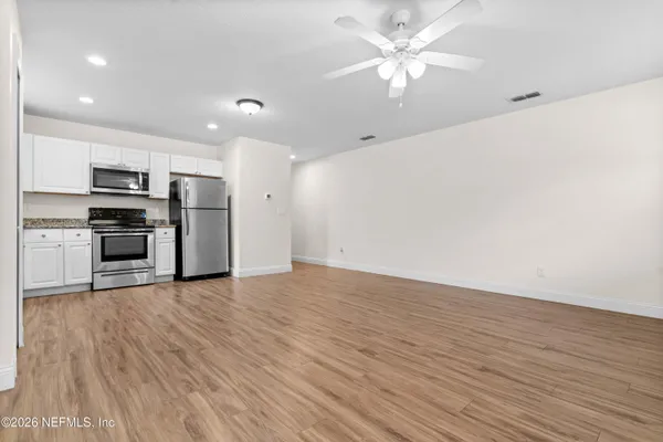 a view of kitchen with sink microwave and stove top oven