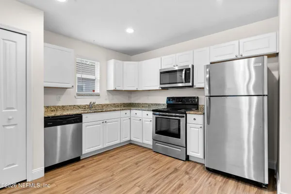 a kitchen with a refrigerator stove top oven and sink