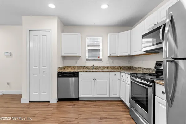 a kitchen with stainless steel appliances granite countertop a stove a sink and a microwave