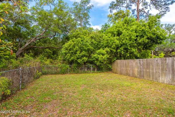 a view of yard with swimming pool and wooden fence