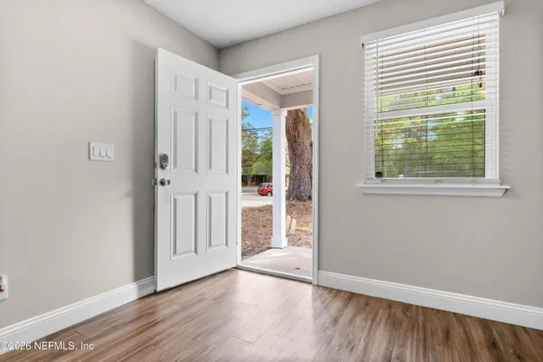 an empty room with wooden floor and windows