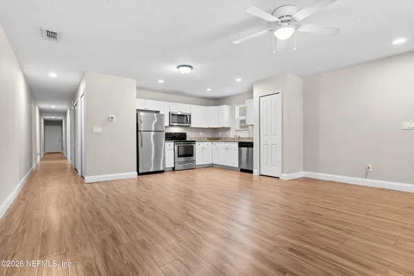 a view of a kitchen with a sink a refrigerator and a stove top oven