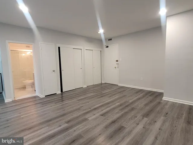 a view of an empty room with wooden floor