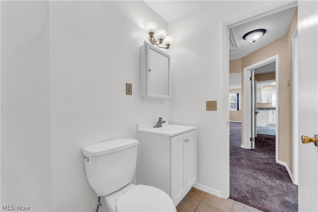 9716 Alexander Road Cleveland, OH 44125 - Photo 17 of 30 Half bath with light colored carpet, vanity, and light tile patterned flooring