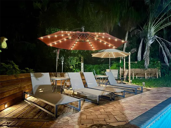 a view of backyard with outdoor seating and trees