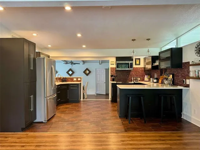 a kitchen with stainless steel appliances granite countertop a refrigerator stove top oven and sink