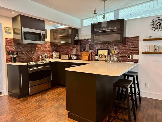 a kitchen with stainless steel appliances a stove sink microwave and cabinets