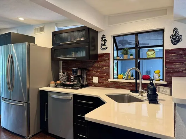 a kitchen with stainless steel appliances a sink cabinets and a refrigerator