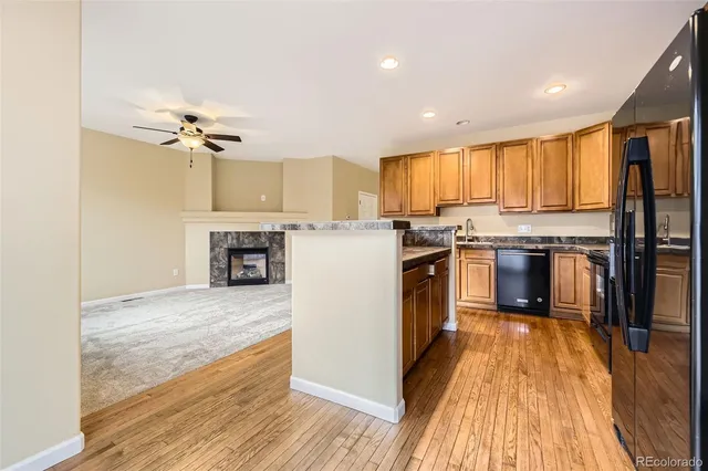 a kitchen with stainless steel appliances granite countertop a stove top oven a sink and a refrigerator