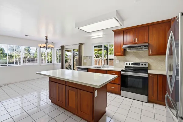 a kitchen with stainless steel appliances granite countertop a stove a sink and a refrigerator