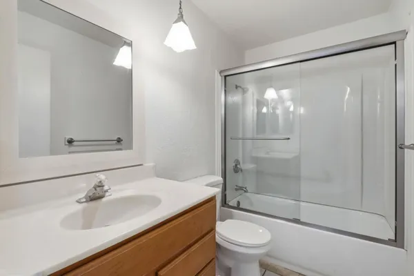 a bathroom with a sink a toilet and shower