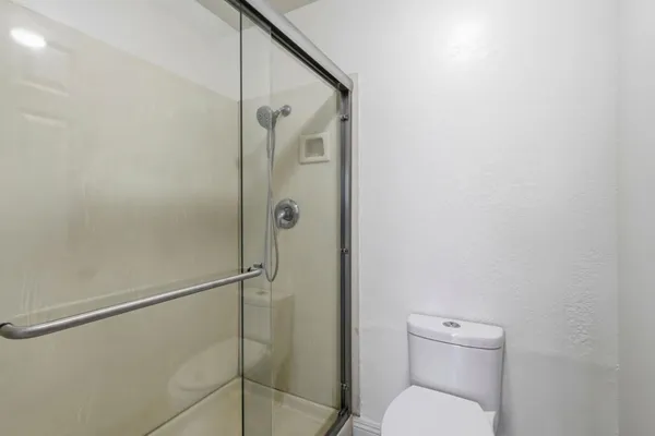 a bathroom with a toilet and a shower