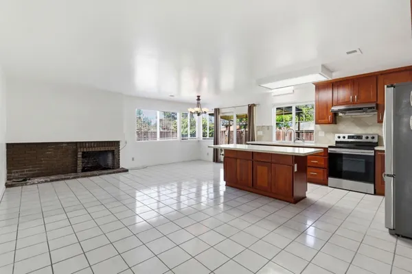 a large kitchen with a stove a sink dishwasher and a microwave oven on the kitchen countertops