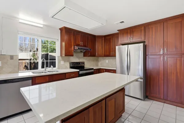 a kitchen with stainless steel appliances a refrigerator sink and cabinets