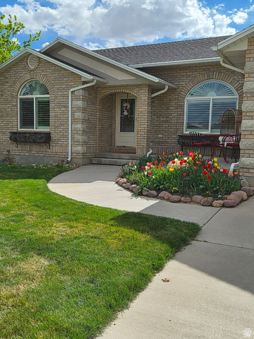 1697 West 2450 Vernal, UT 84078 - Photo 2 of 36 View of exterior entry with a yard, brick siding, and a shingled roof