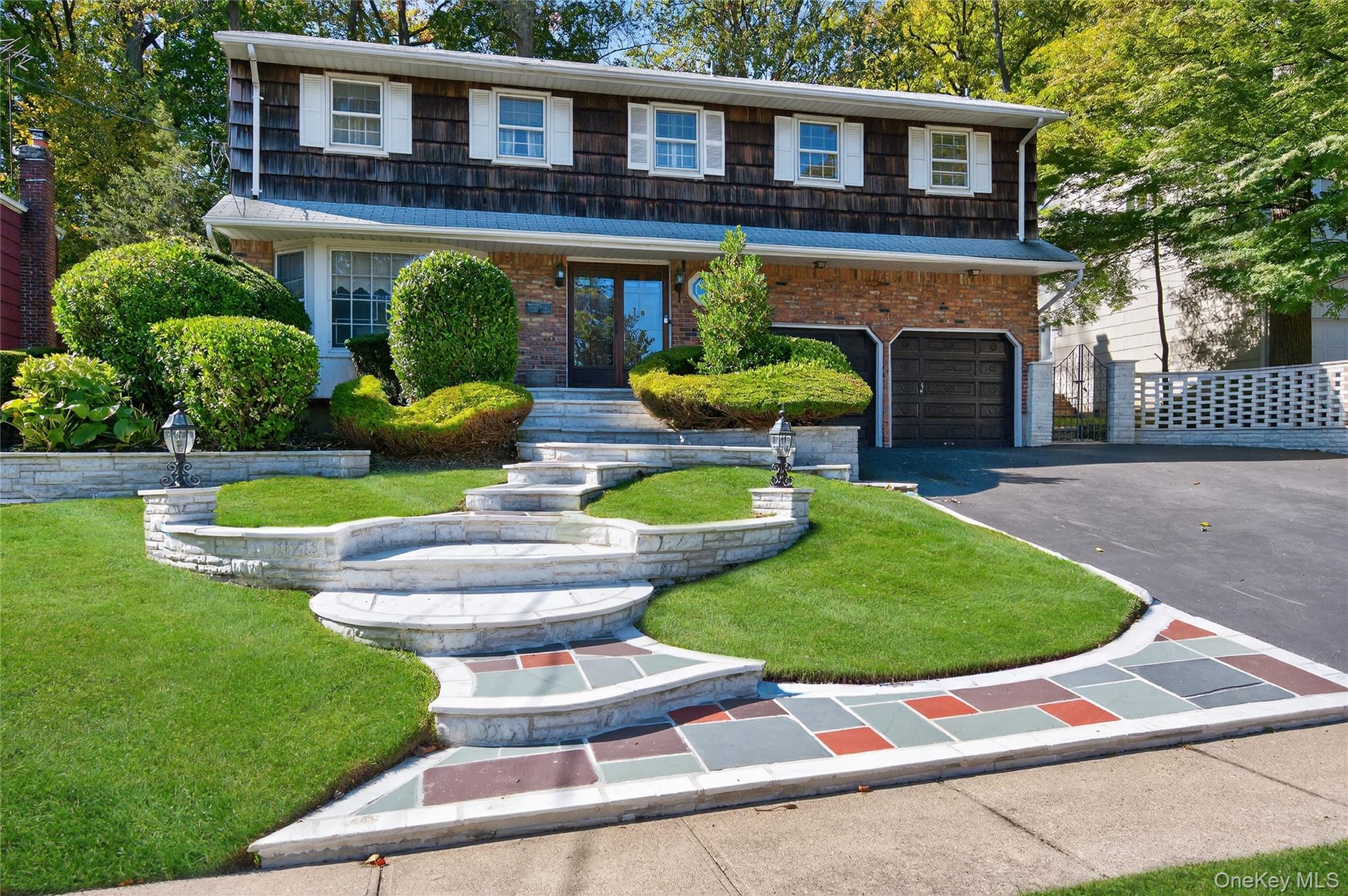 a front view of a house with garden and chairs