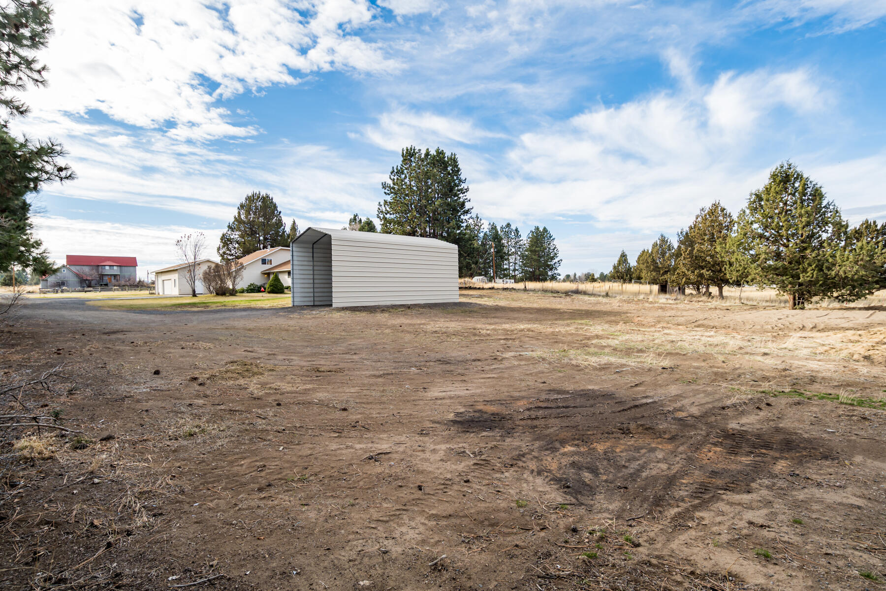 61825 Dobbin Road Bend, OR 97702 - Photo 36 of 43 a view of a white house and a yard with trees