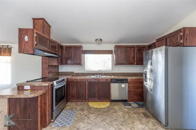 a kitchen with stainless steel appliances granite countertop a stove a refrigerator and a sink