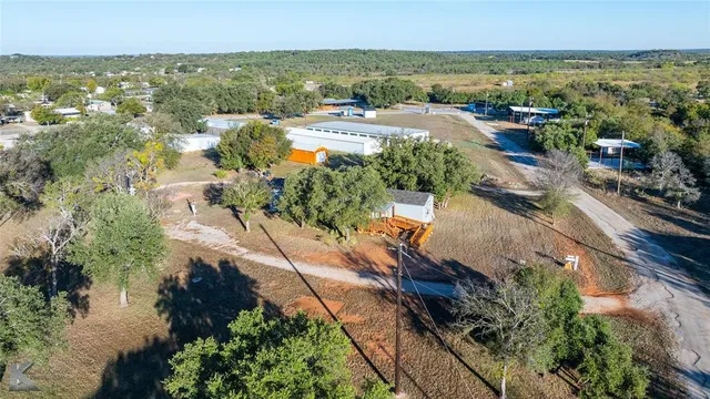 an aerial view of ocean and residential houses with outdoor space