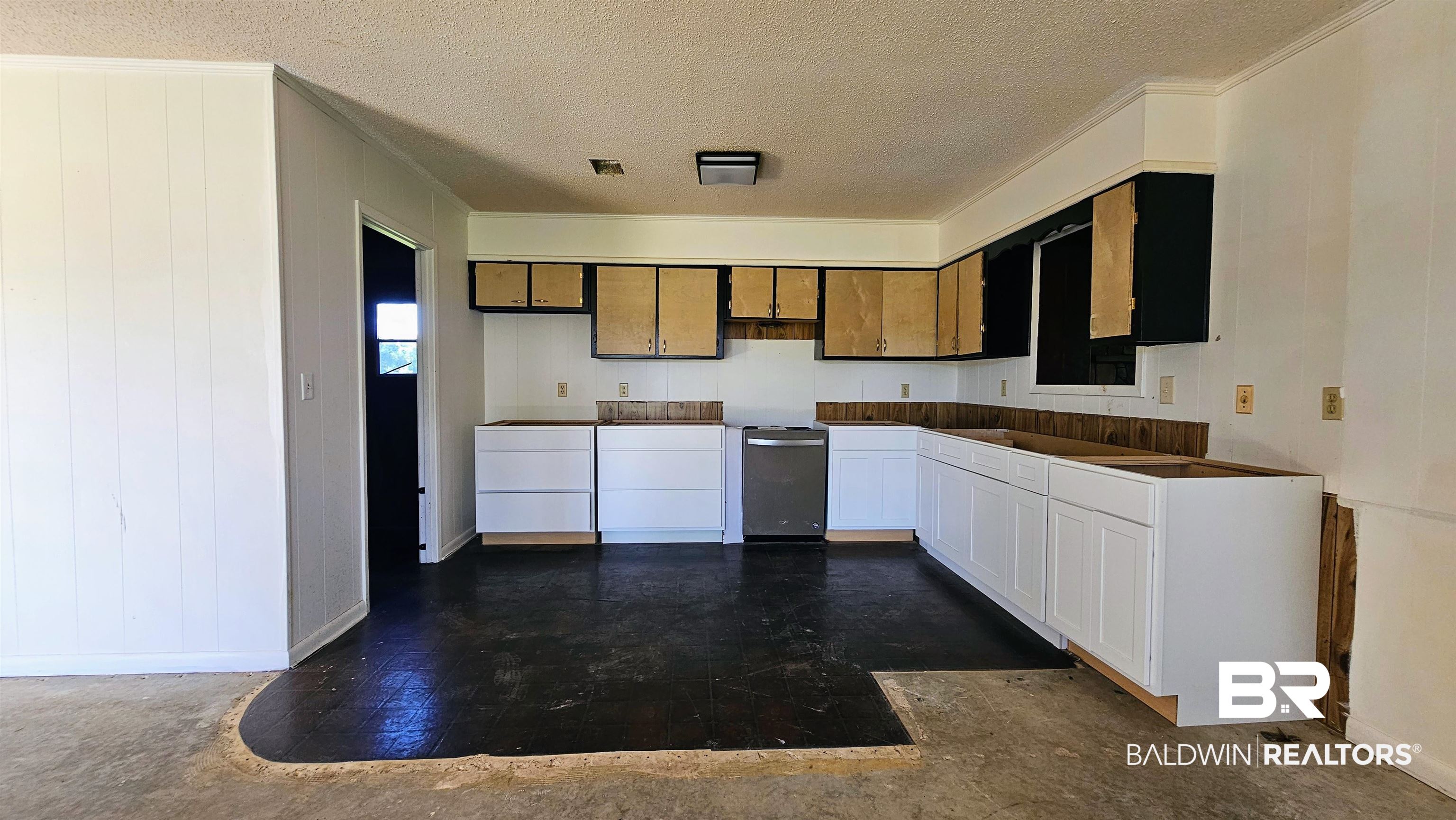 18824 Highway 41 Brewton, AL 36426 - Photo 6 of 40 Kitchen featuring new white base cabinetry, existing upper cabinetry, a stainless steel dishwasher, and dark flooring