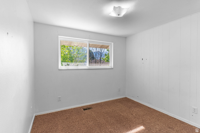 728 400 East Orem, UT 84097 - Photo 25 of 30 Room featuring a single horizontal window, overhead flush-mount lighting, and wall-to-wall carpeting