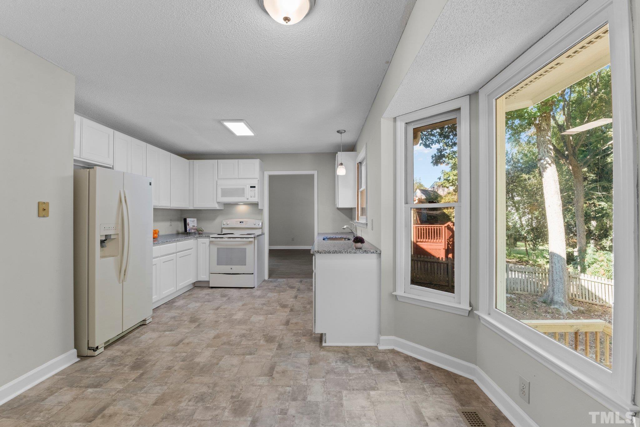4405 Birmingham Way Raleigh, NC 27604 - Photo 2 of 22 a kitchen with white cabinets and a refrigerator