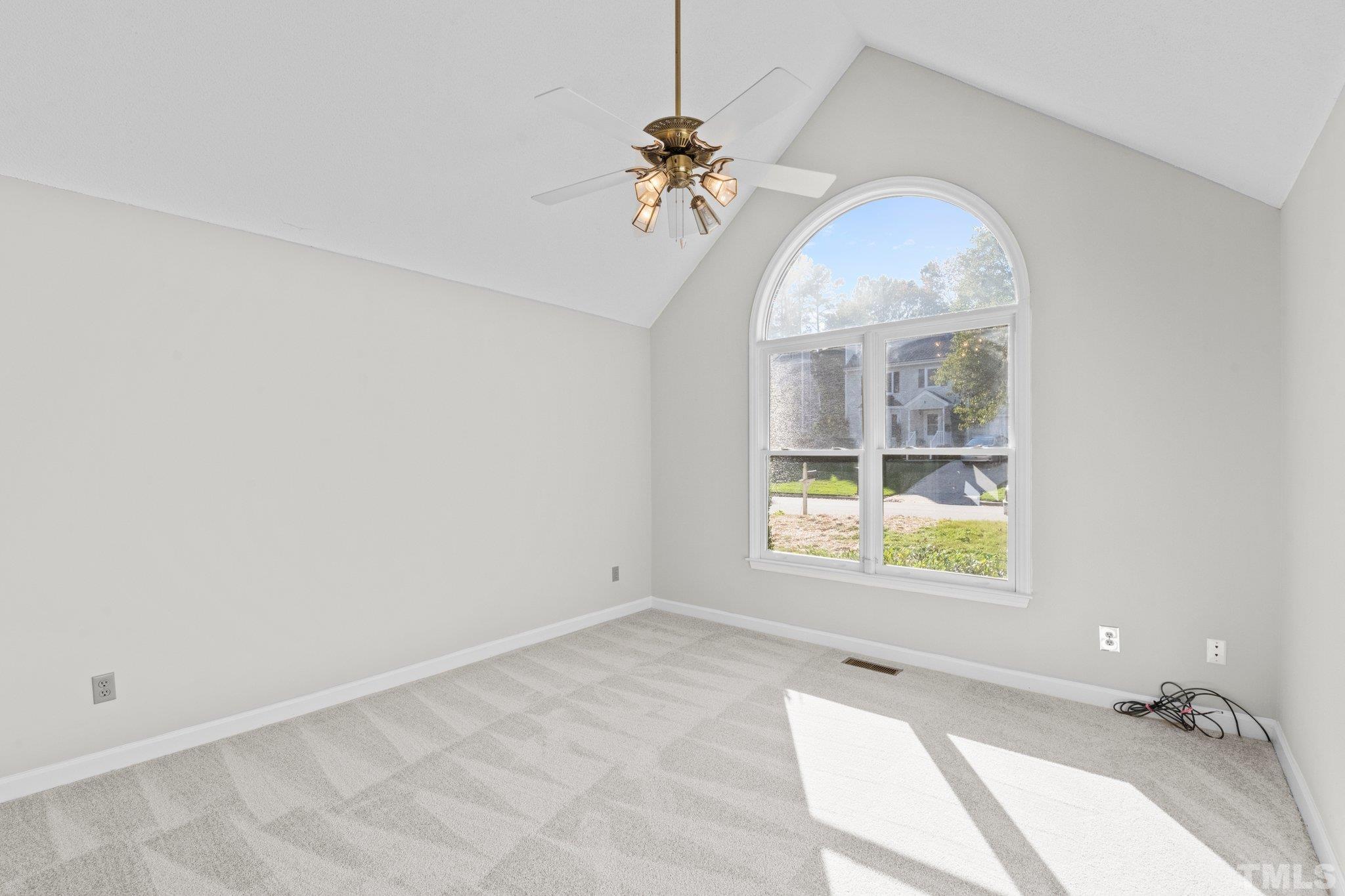 4405 Birmingham Way Raleigh, NC 27604 - Photo 3 of 22 an empty room with a chandelier fan and windows